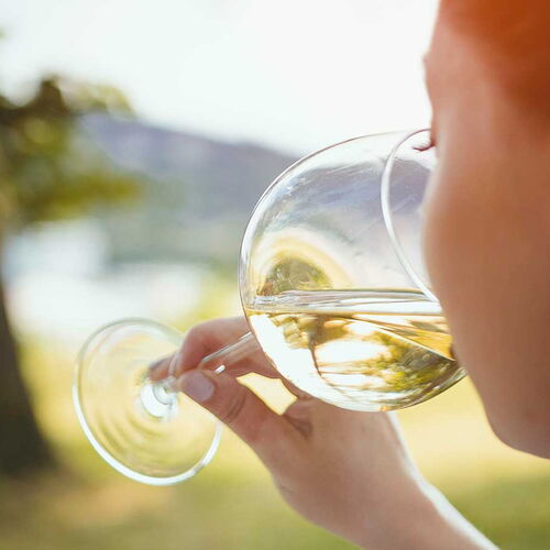 Eine Frau trinkt aus einem Glass Weisswein